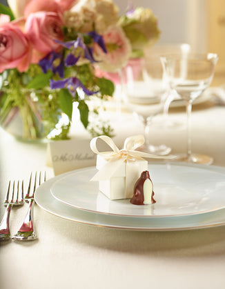 Our custom Chocolate Penguin favor sitting amongst an elegant event table setting.