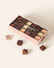 Light pink box containing assorted square bonbons.