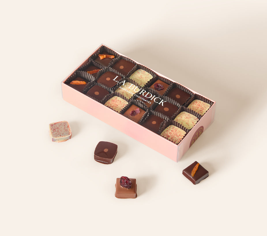 Light pink box containing assorted square bonbons.
