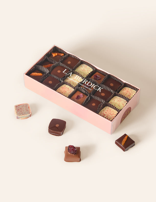 Light pink box containing assorted square bonbons.