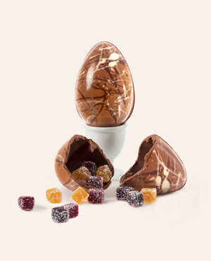 Speckled hollow milk chocolate egg filled with colorful fruit jelly cubes