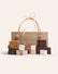 Bag with the components to make s’mores in front, gram crackers, marshmallows and chocolate bars on a cream background.
