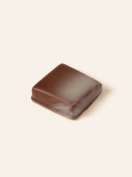 Square dark chocolate bonbon with a gradient of white chocolate on the right.