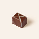 Rectangular dark chocolate bonbon decorated with crossing white chocolate lines to resemble the Scottish flag.