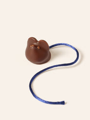 Dark chocolate mouse with milk chocolate eyes and nose and a blue silk tail.