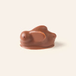 Milk chocolate bunny bonbon on a light cream background