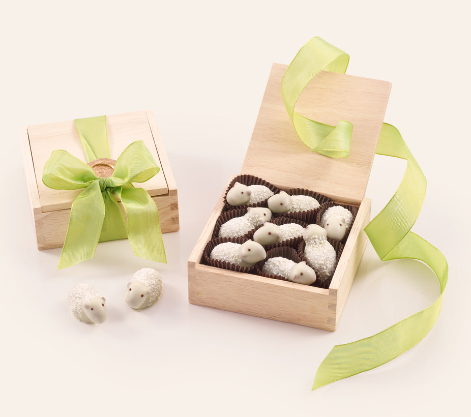 Eight pieces of white chocolate sheep in a wooden gift box with green ribbon