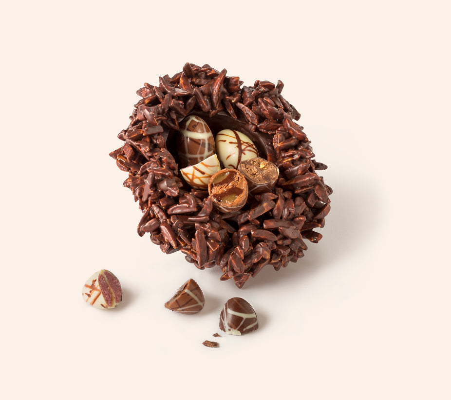 Chocolate bird’s nest made from slivered almonds coated in dark chocolate, filled with five speckled chocolate Easter eggs