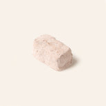 Single rectangular piece of artisan chocolate with a powdery coating on a plain light background