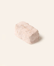 Single rectangular piece of artisan chocolate with a powdery coating on a plain light background