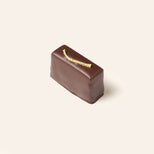 Chocolate bonbon with a lemon peel accent on a beige background