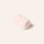 Rectangular chocolate bonbon covered in pink powdered sugar on a cream background