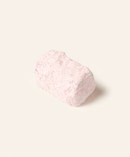Rectangular chocolate bonbon covered in pink powdered sugar on a cream background