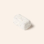 Rectangular chocolate bonbon covered in white powdered sugar on a cream background.