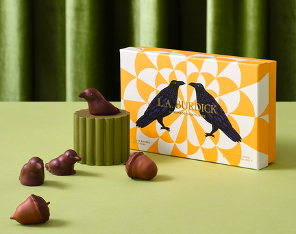 Chocolate ravens and acorns on a green background with an orange and white box on the right.