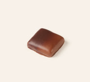 Square dark and milk chocolate bonbon on a cream background