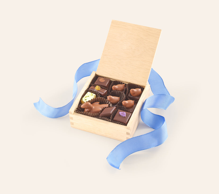 Small Chocolate Mother Duck & Ducklings assortment of bonbons in a wooden gift box with blue ribbon.